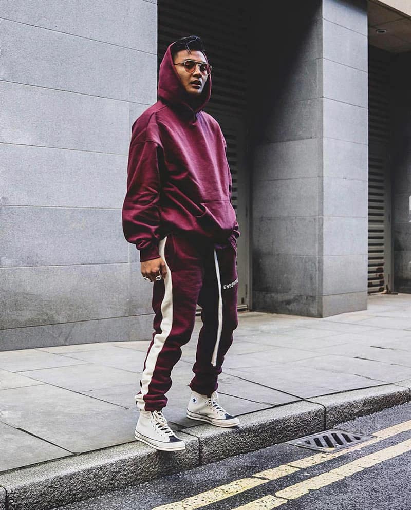 Fear of god essentials hoodie and sweatpants in burgundy with white accents, streetwear style, casual and trendy apparel.