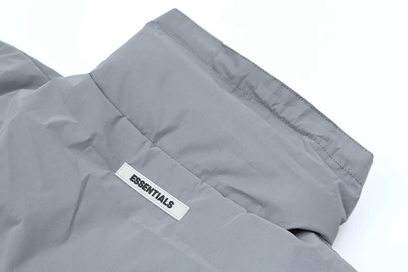 2. Minimalist gray Fear of God Essentials jacket with a focus on the logo tag.