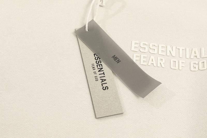 Premium Fear of God Essentials clothing tag and apparel, minimalistic design with branding details, highlighting stylish and comfortable streetwear fashion.