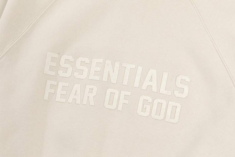 Solid white Fear of God Essentials logo printed on a minimalist hoodie or sweatshirt, emphasizing comfort and style.